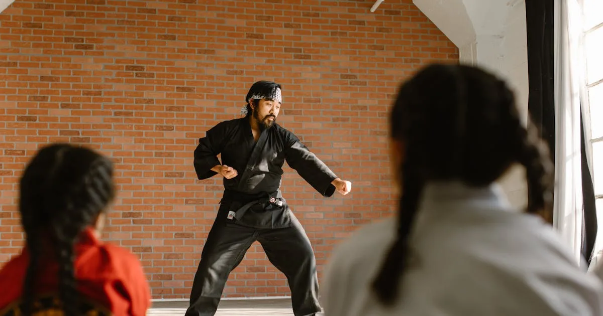 Martial artists in white uniforms and black belts, standing in a row with clenched fists, conveying discipline and unity
