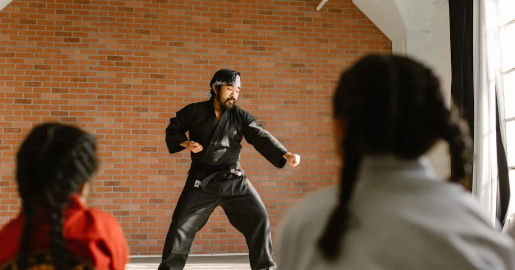 Martial artists in white uniforms and black belts, standing in a row with clenched fists, conveying discipline and unity