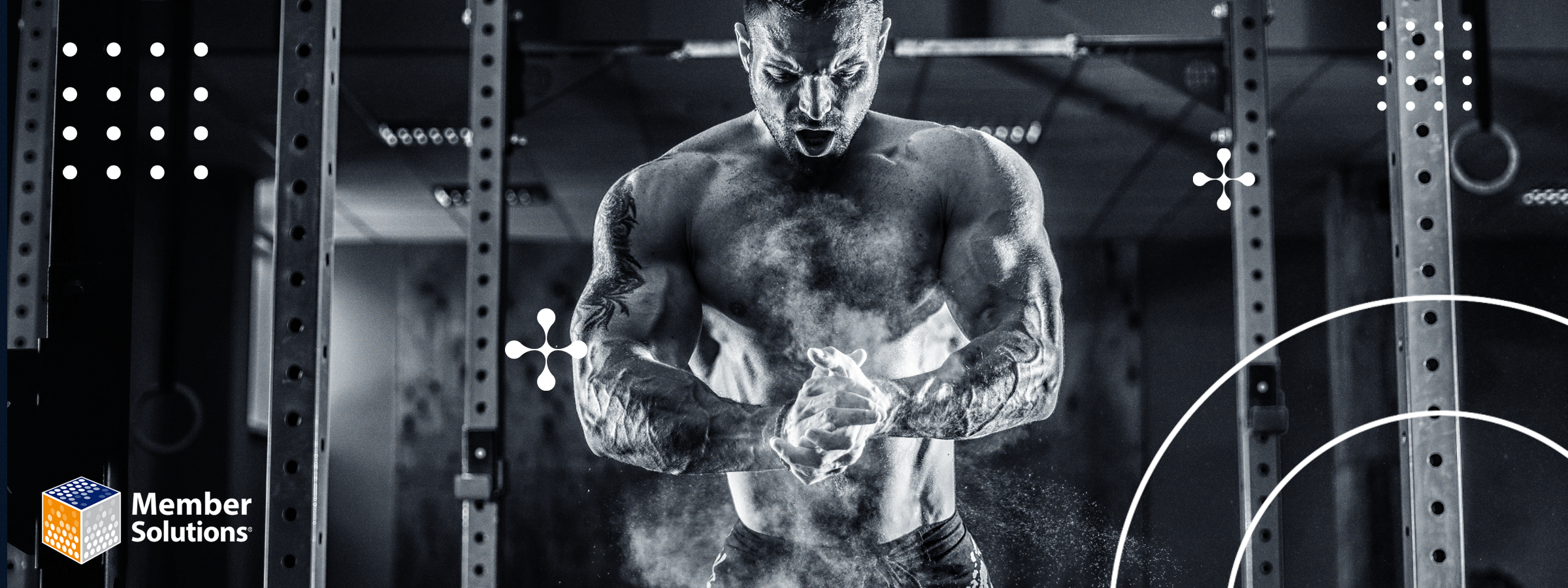A muscular man in a gym claps chalked hands, creating a cloud of dust