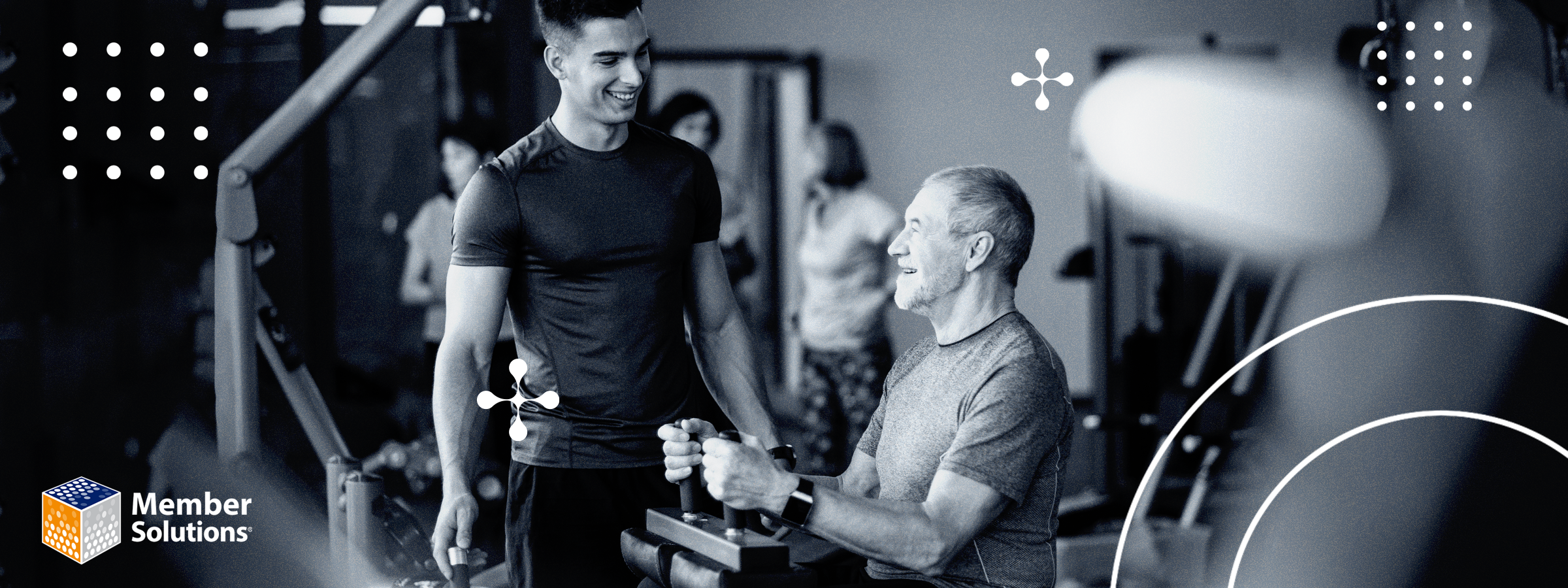 Smiling young trainer assisting an older man on a weight machine in a gym