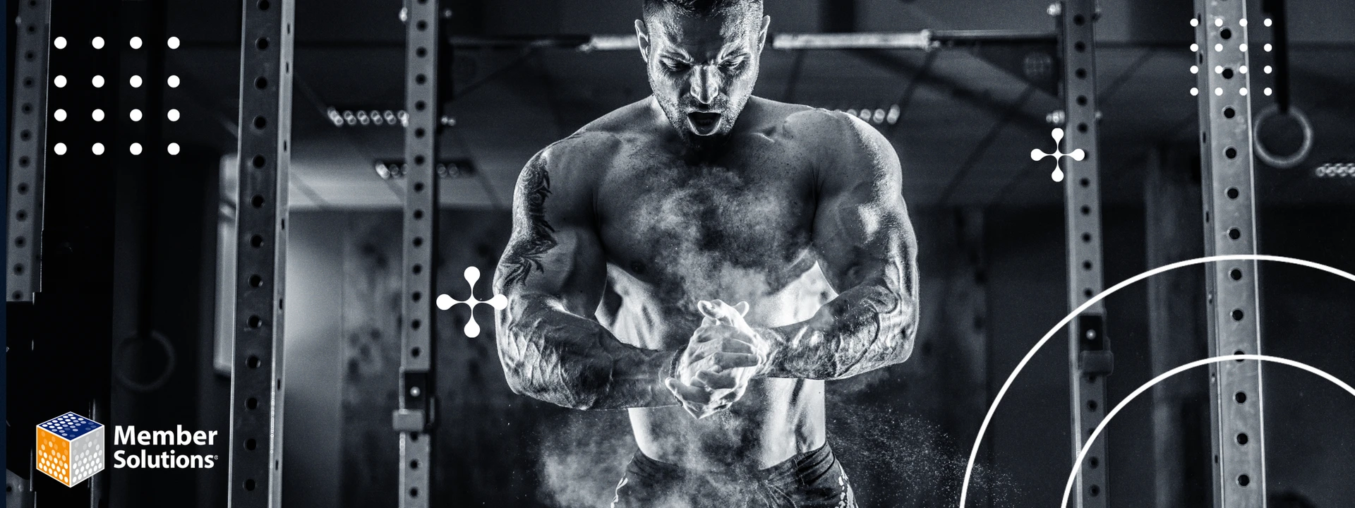 A muscular man in a gym claps chalked hands, creating a cloud of dust