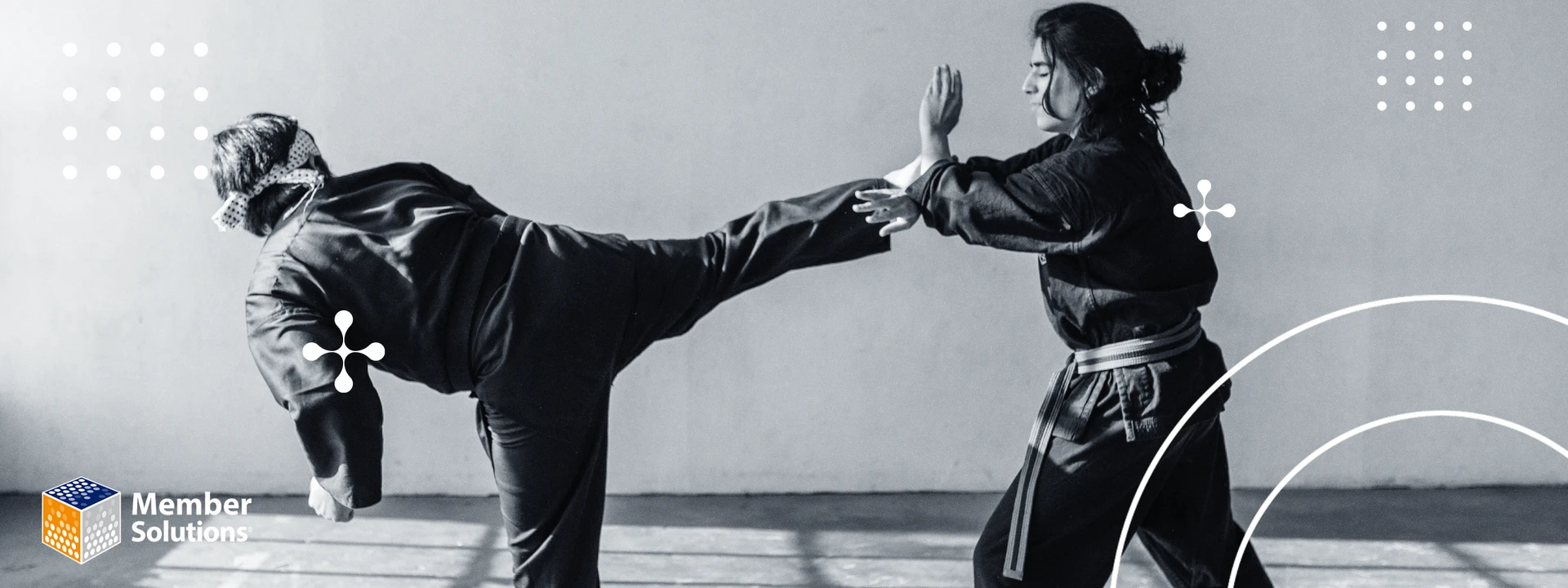 Two martial artists in mid-action, one executing a high kick while the other blocks with their arm